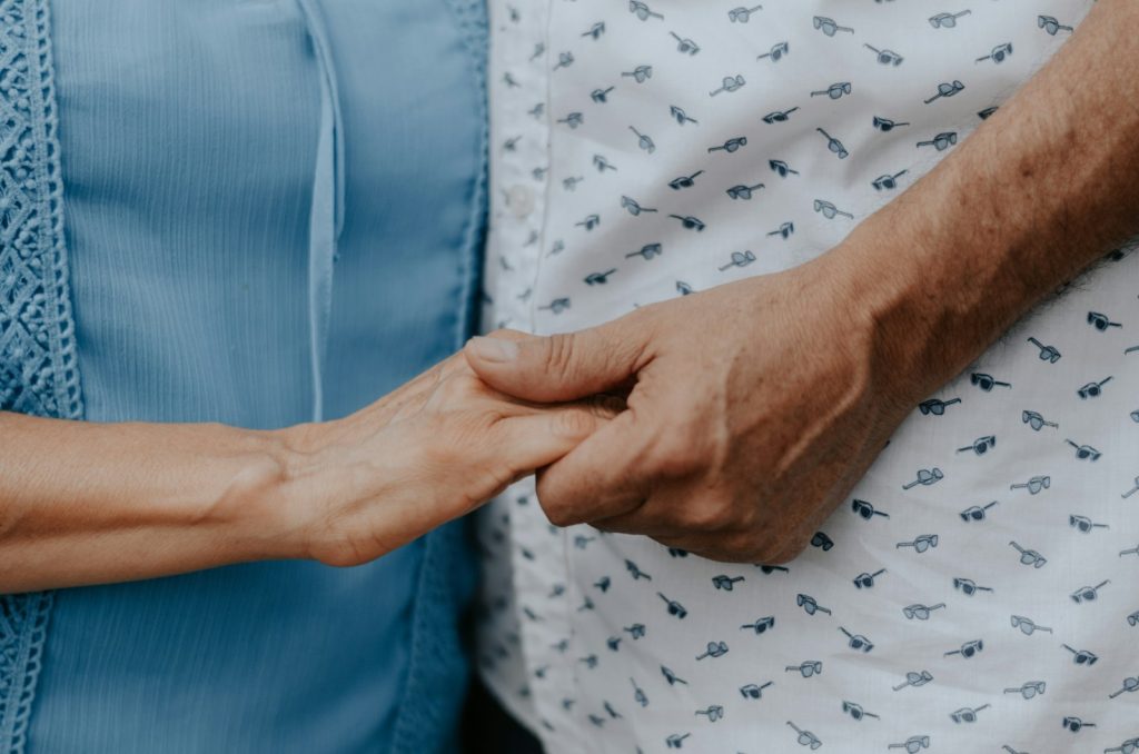 Carer holding the hand of an older person